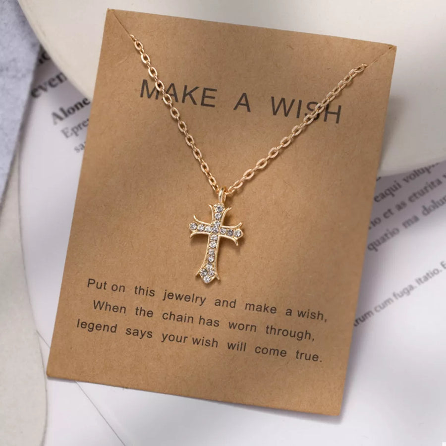 Gold rhinestone cross pendant necklace with delicate chain.