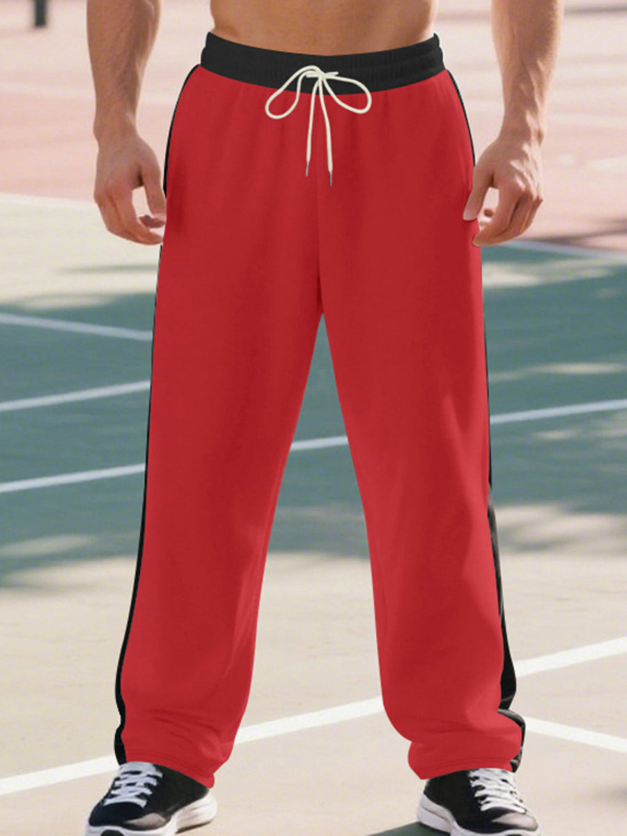 Men's bright red wide-leg sweatpants with black side stripe and drawstring.