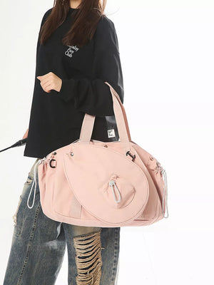 Pink nylon athletic tote bag with racket holder and cinch cord closure.