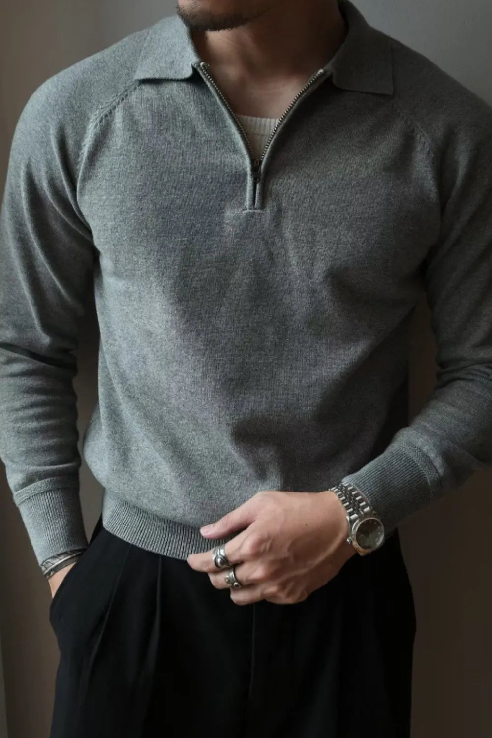 Raglan sleeve knit polo in dark gray with zip-through neckline.