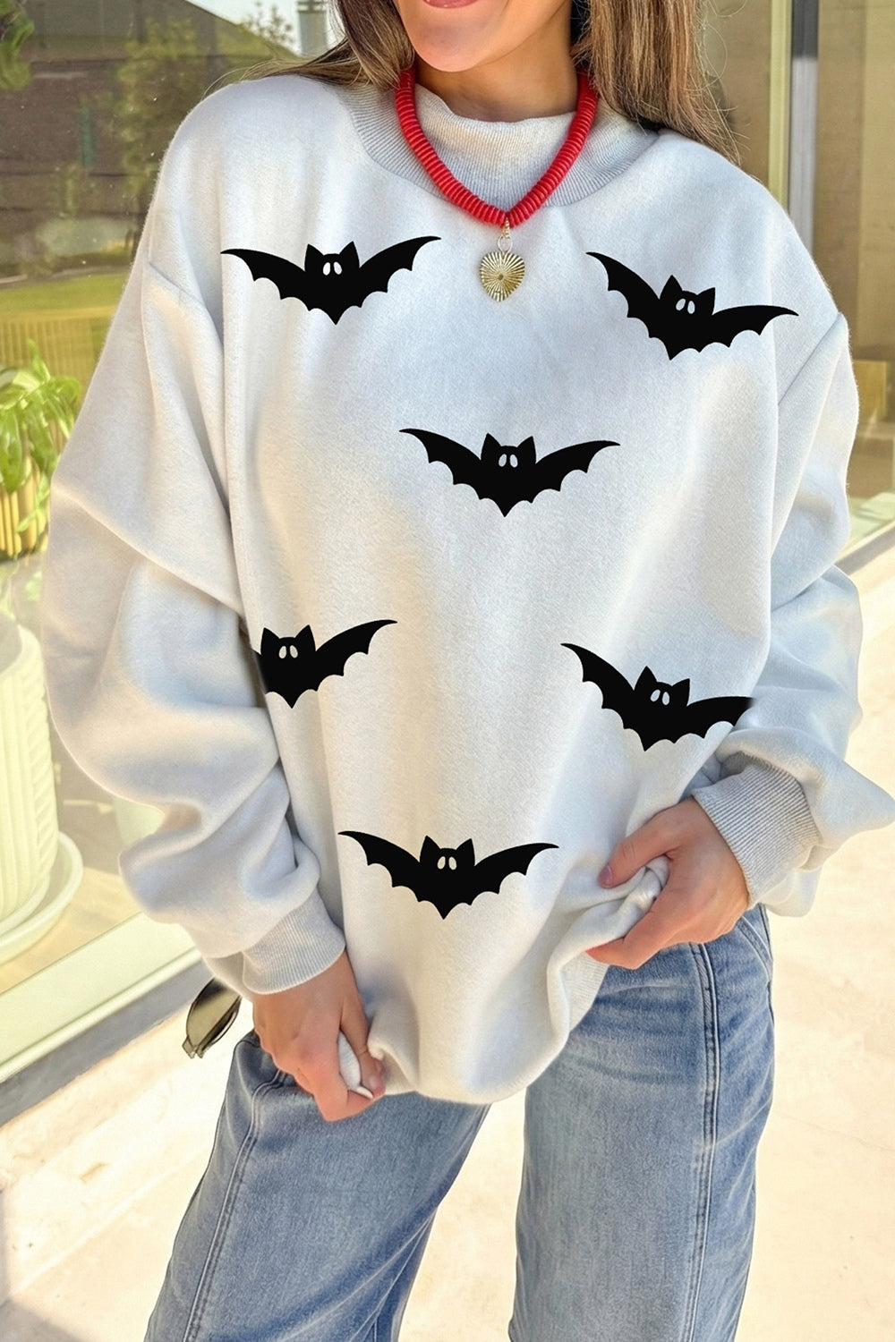 off-white mock neck sweater with bat-print and mock neck