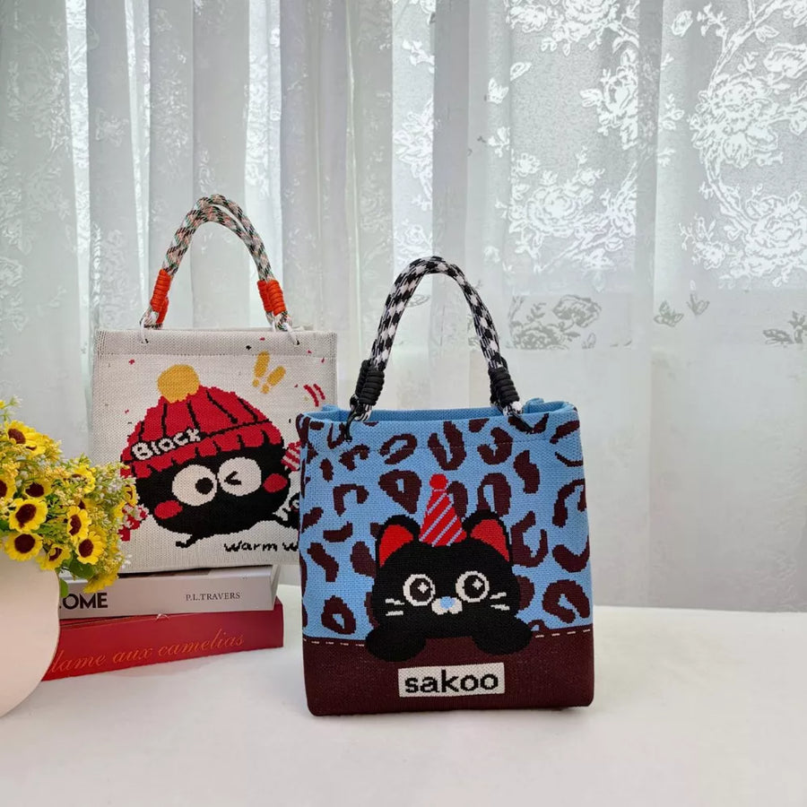 Cartoon graphic tote handbag in blue with leopard print and black cat design.