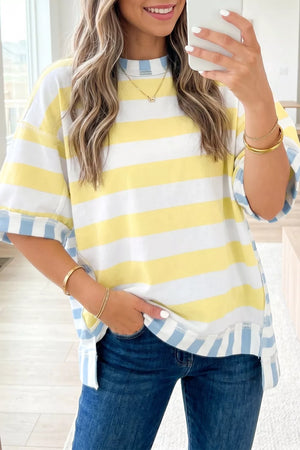 Striped t-shirt with yellow and white horizontal stripes and blue and white vertical striped cuffs and hem.