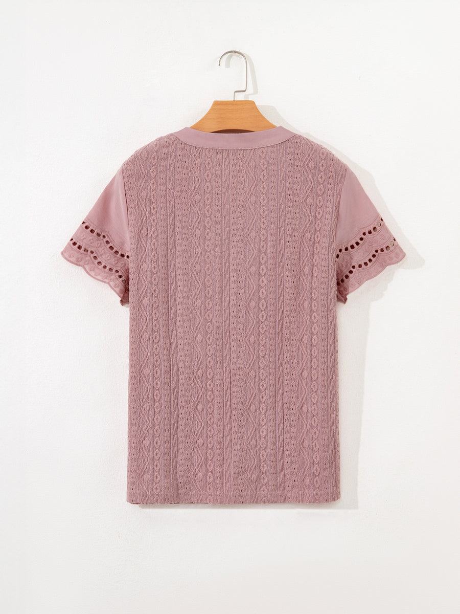 Pink eyelet embroidered short-sleeve blouse with cutout details on sleeves.