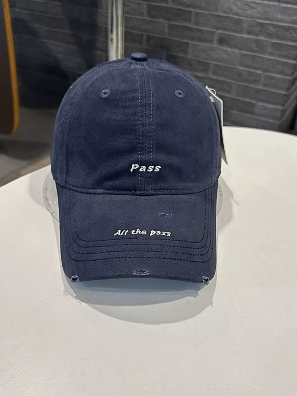 Navy blue distressed cotton baseball cap with embroidered "Pass" and "All the pass" slogans.