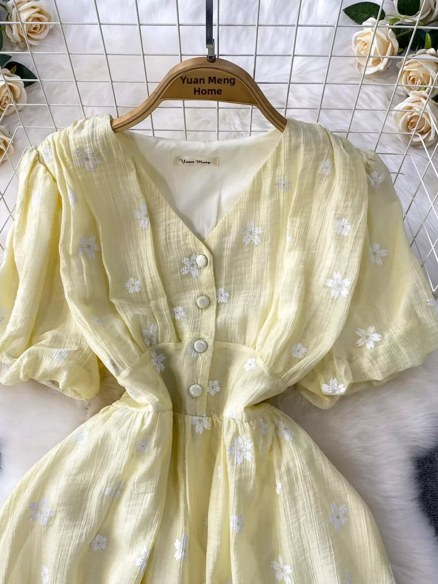Yellow embroidered puff sleeve midi dress with button front and v-neck.