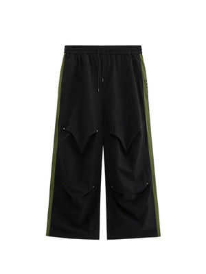 Black relaxed fit sweatpants with drawstring and olive green side stripe detail.