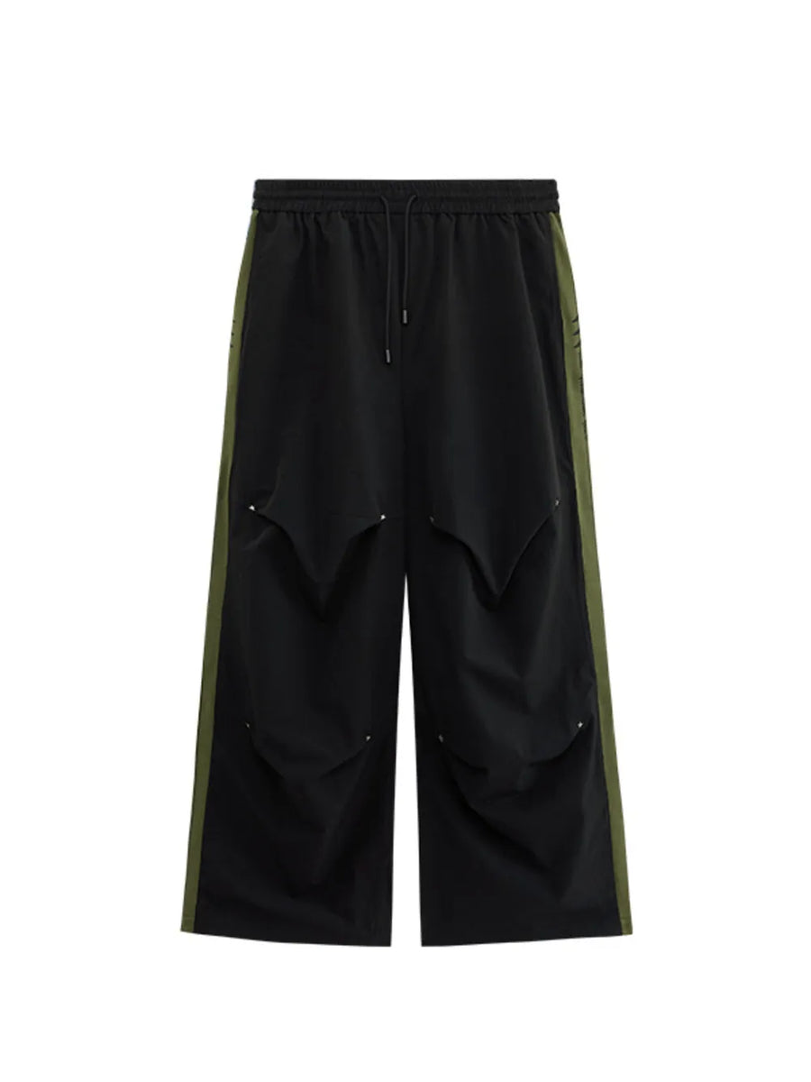 Black relaxed fit sweatpants with drawstring and olive green side stripe detail.