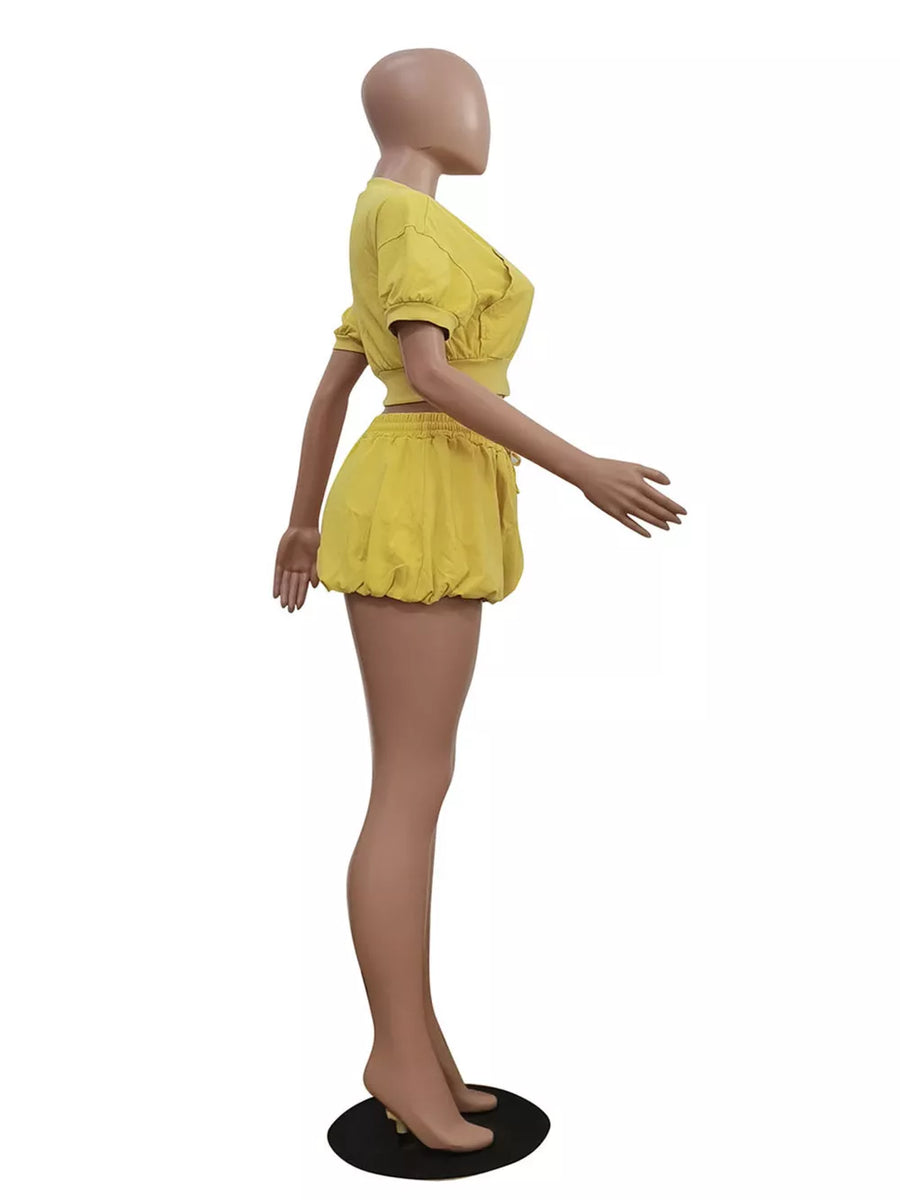 Yellow zip-up crop top and drawstring shorts set with puff sleeves and elastic waist.