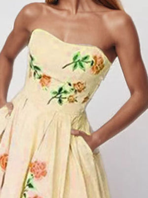 Floral print strapless maxi dress in blush pink with pockets and a full skirt.