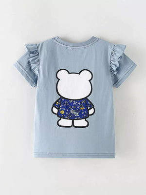Light blue cotton t-shirt with ruffled sleeves and a playful bear graphic wearing a floral shirt.
