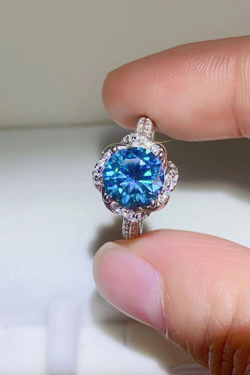 Blue moissanite halo ring with diamond accents on band