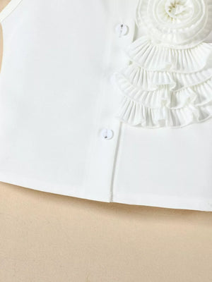 White ruffled top with decorative button detail and layered ruffles.