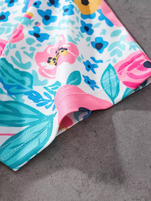 White t-shirt with a colorful floral print and pink trim.