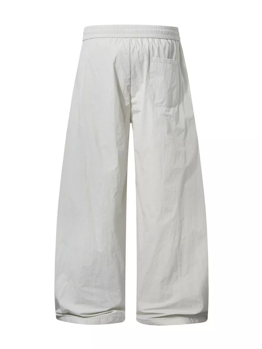 Men's cream white wide-leg cargo pants with elastic waist and back pocket.