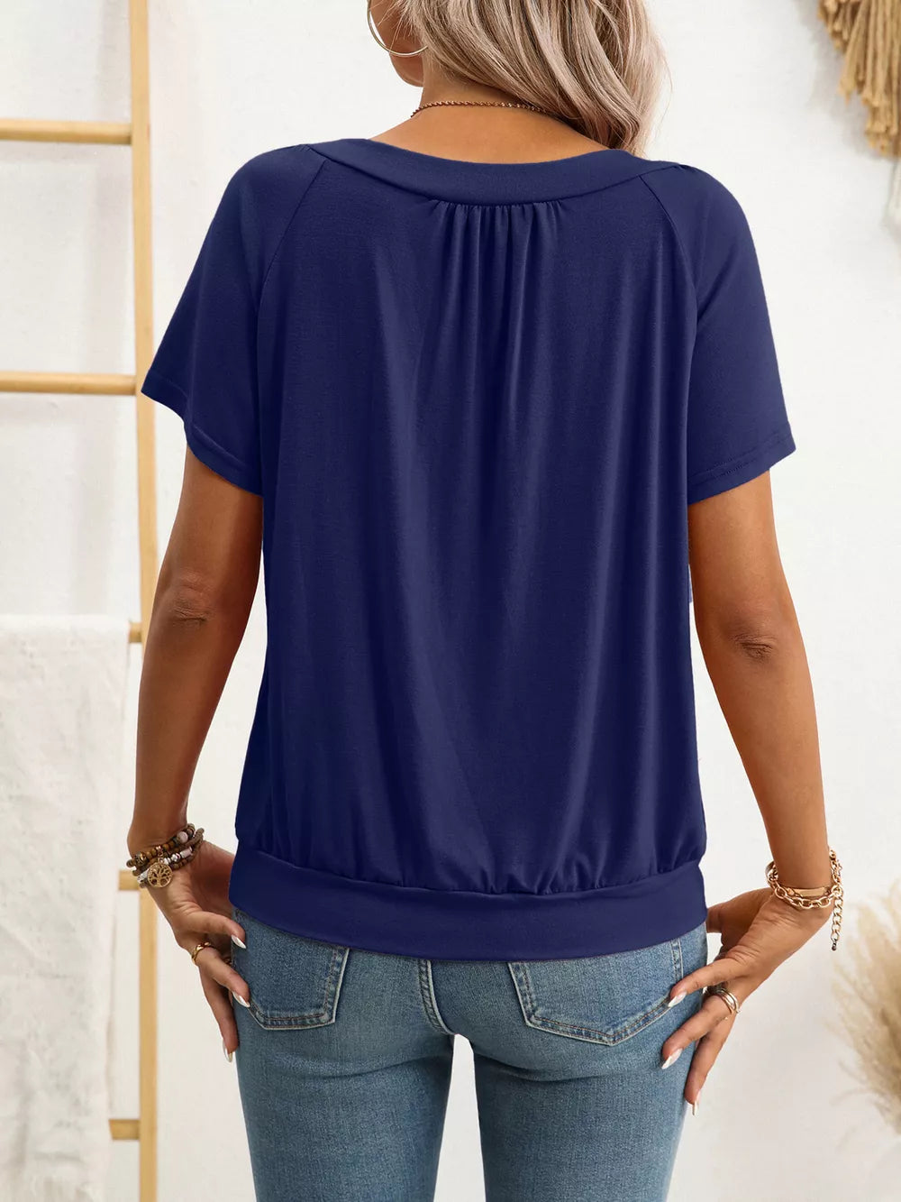 Navy blue ruched V-neck t-shirt with short sleeves and banded hem.
