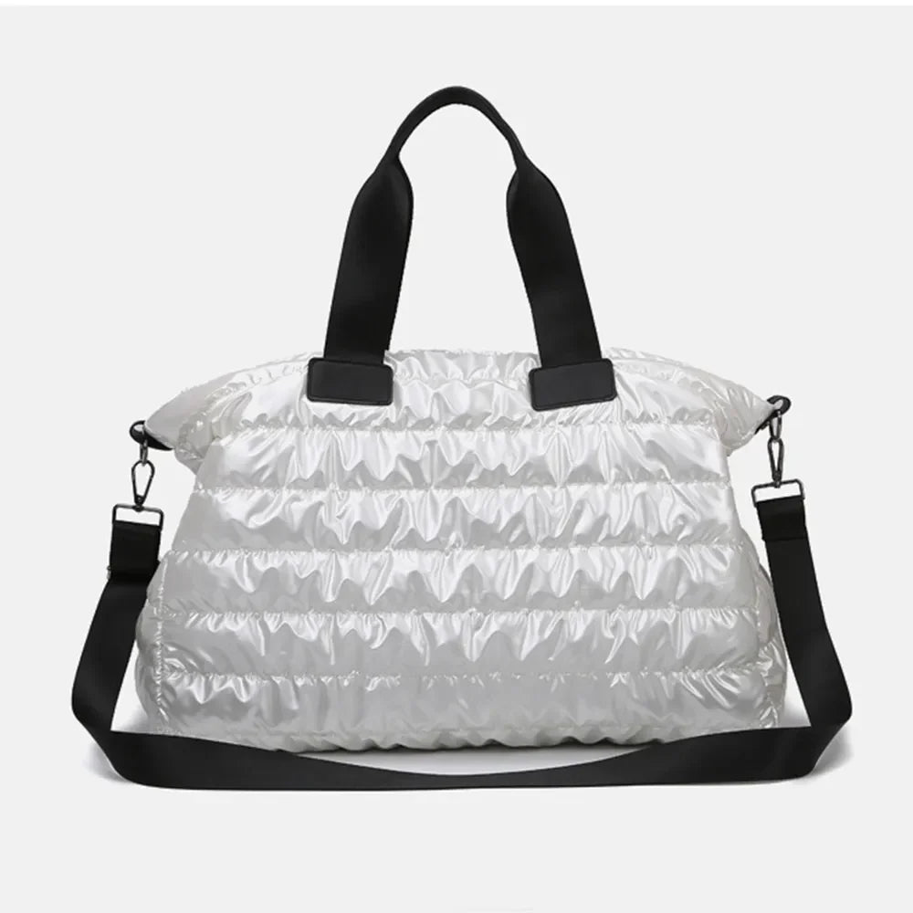 Glossy white padded holdall bag with black straps and a detachable crossbody strap.