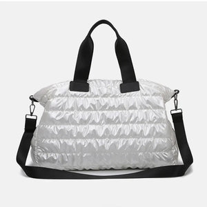 Glossy white padded holdall bag with black straps and a detachable crossbody strap.