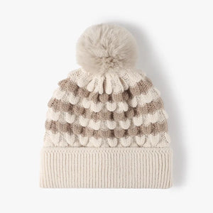 Beige and gray striped knit beanie with a pom pom and scalloped detail.