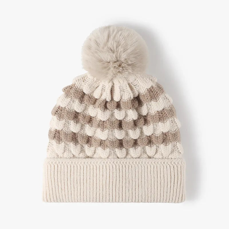 Beige and gray striped knit beanie with a pom pom and scalloped detail.