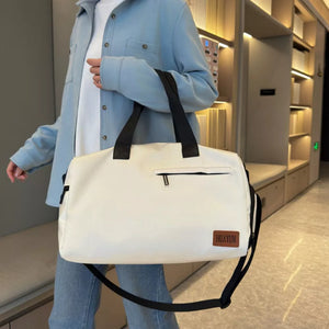 Creamy-white nylon duffel bag with black straps and a zippered pocket.