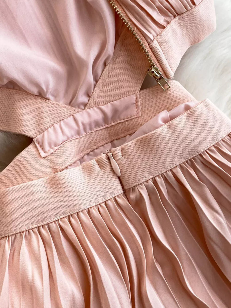 Pink pleated maxi dress with cutout detail and zipper closure.