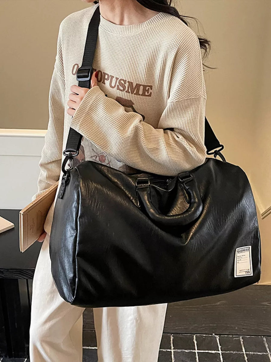Black pu leather travel bag with top handles and adjustable shoulder strap