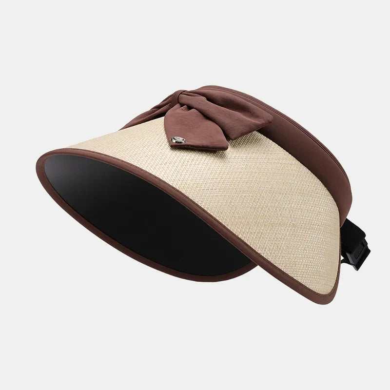 Bow-adorned raffia visor with brown trim and adjustable strap
