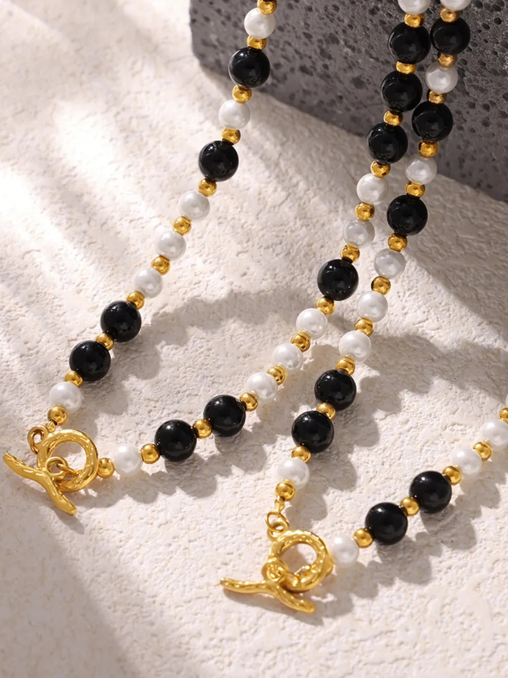 Gold toggle necklace with black onyx and white pearl beads