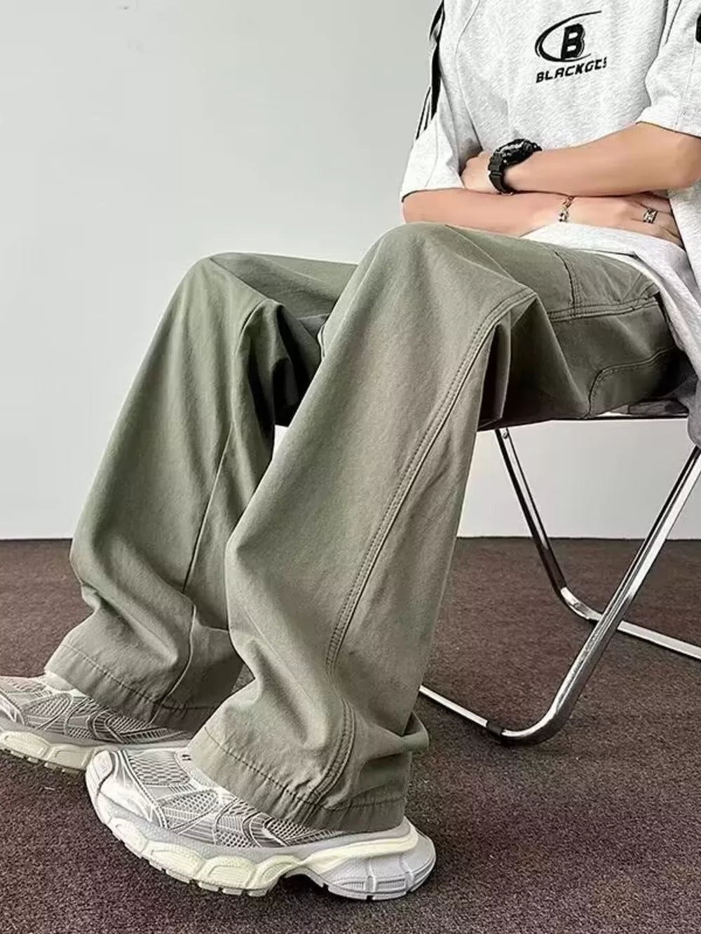 Men's green wide-leg cargo pants with a relaxed fit and visible stitching detail.