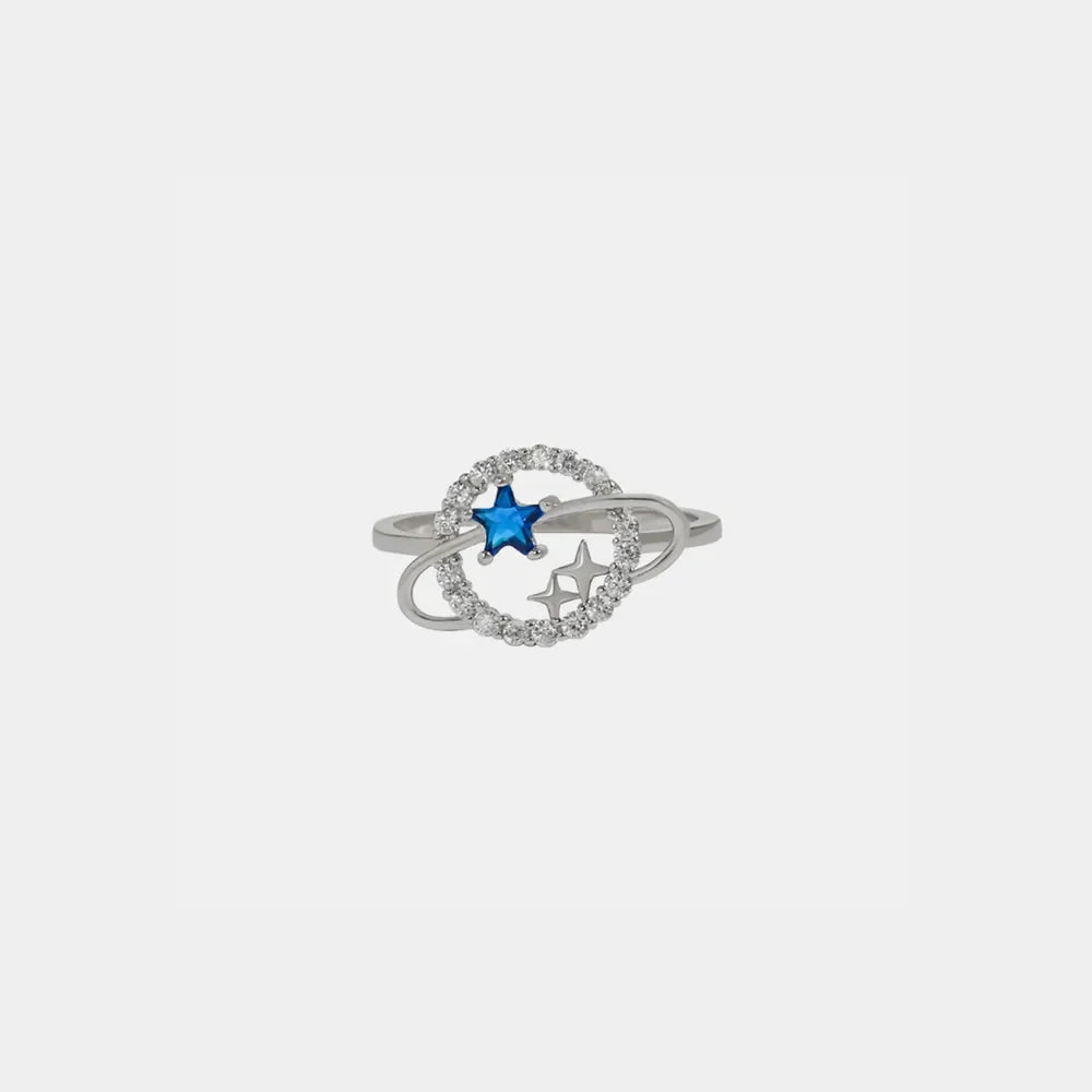 Silver ring with celestial orbit design, blue zircon star, and clear stones