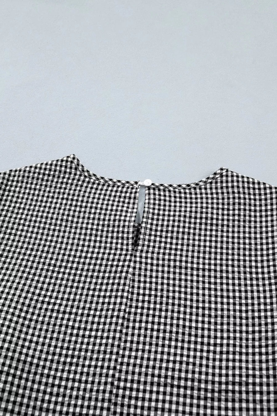 Gingham shirt with ruffled sleeves and bow tie neck detail.