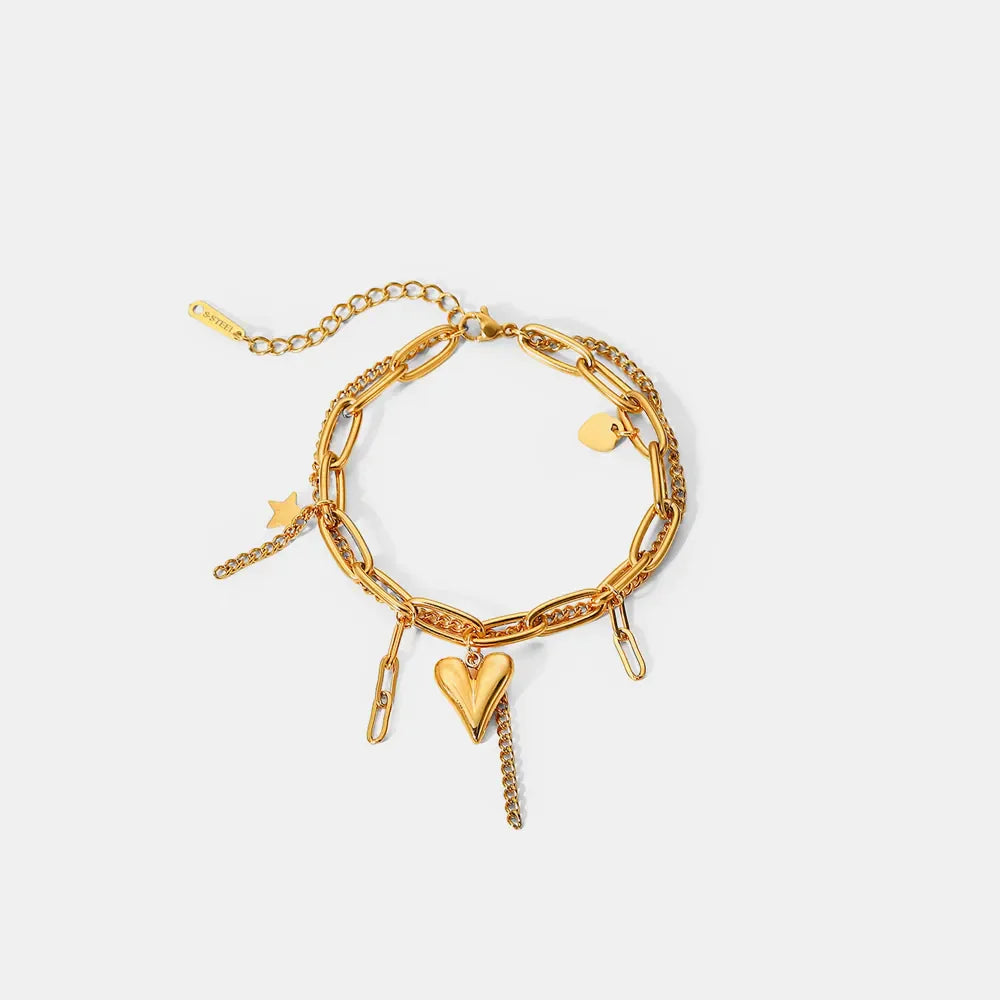 Gold layered chain bracelet with heart, star, and link charms. 18K gold-plated.