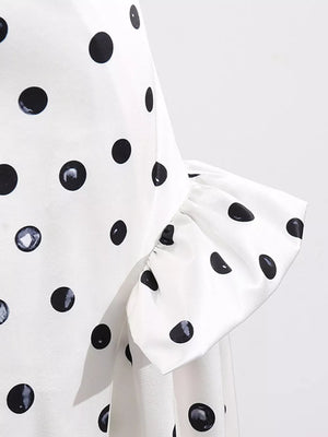 White polka dot dress with ruffled sleeve detail.