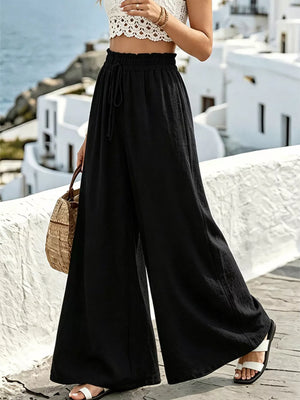 Black wide-leg linen pants with drawstring waist and ruffled detail