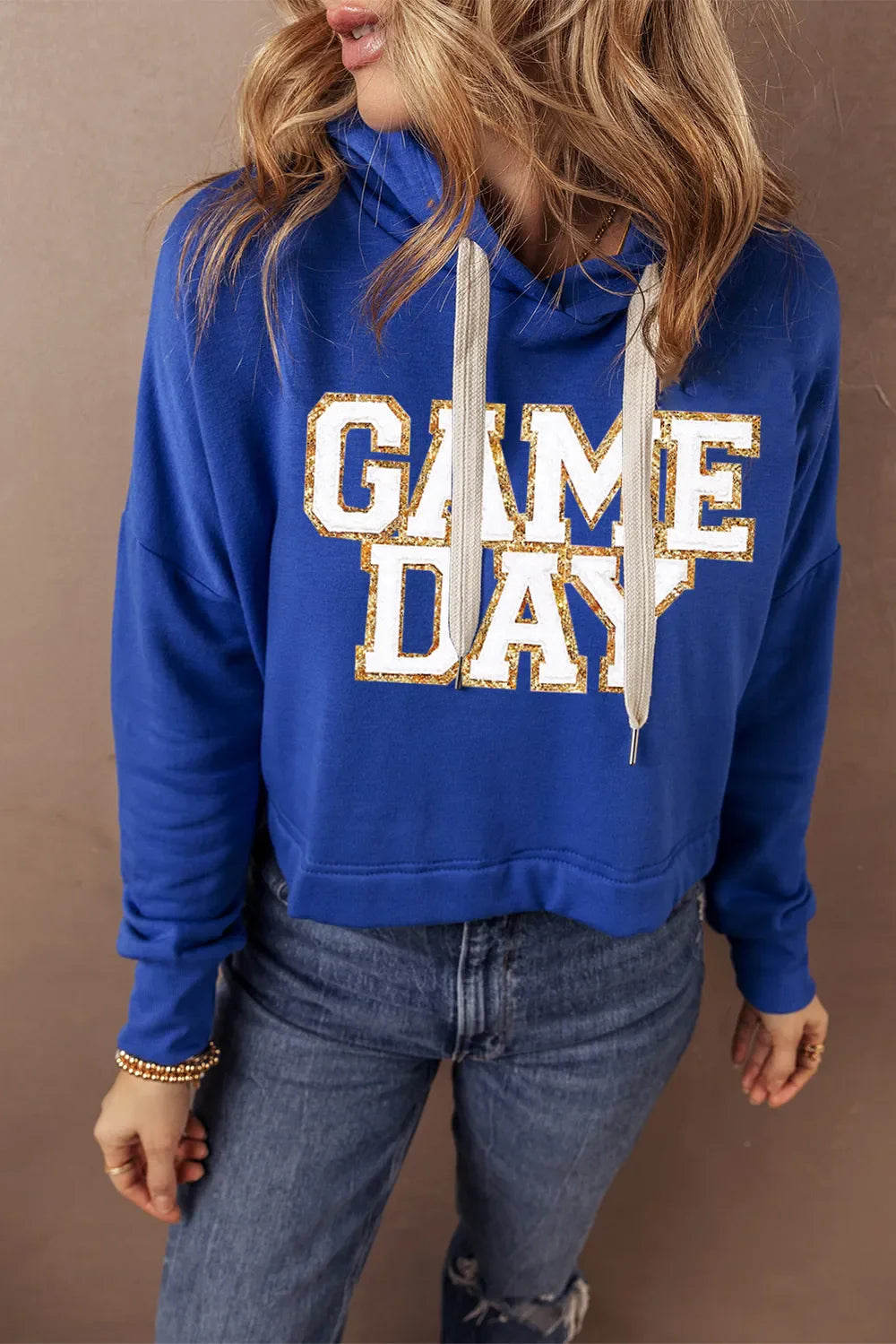 Royal blue cropped hoodie with glitter "GAME DAY" graphic and adjustable drawstring hood.