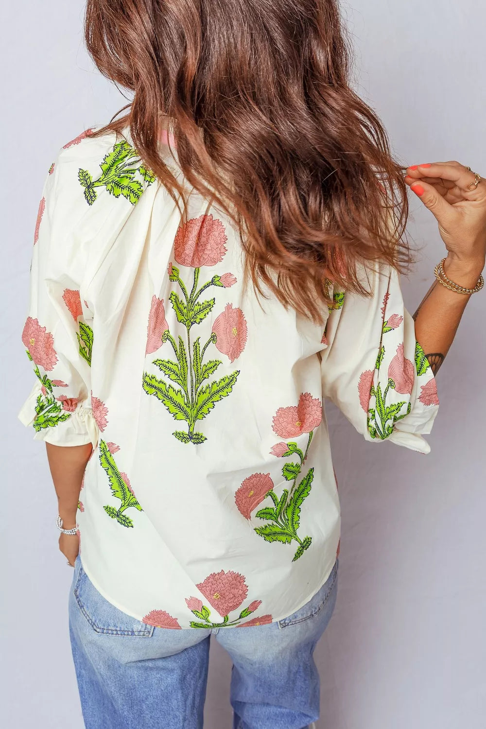 Cotton floral blouse with ruffled sleeves in cream with pink and green print.