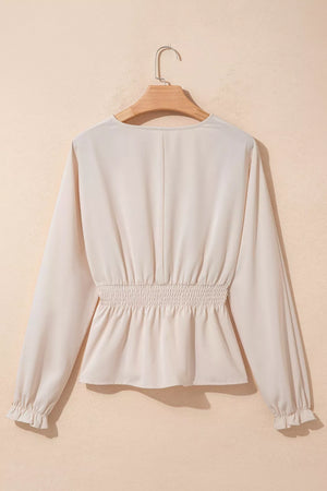 Cream polyester V-neck blouse with smocked waist and ruffled cuffs