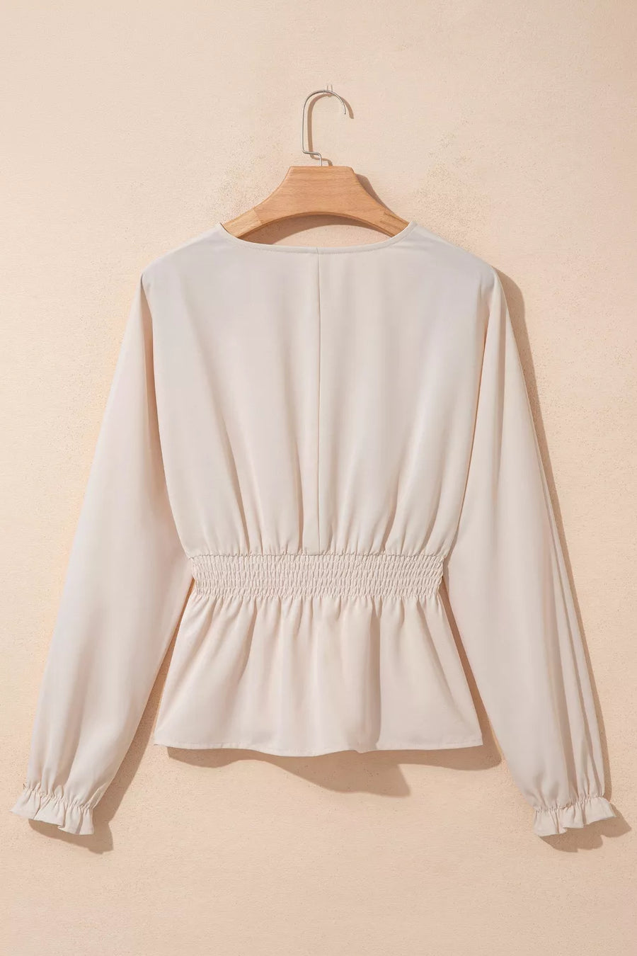 Cream polyester V-neck blouse with smocked waist and ruffled cuffs