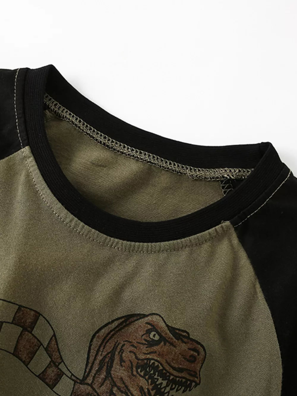 Toddler t-shirt with crew neck, raglan sleeves, and dinosaur graphic on olive green cotton.