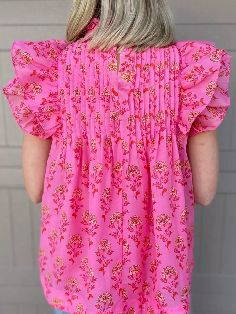 Pink floral print blouse with ruffled flutter sleeves and pintuck detail.
