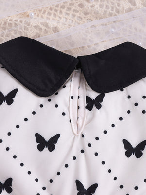Baby dress with black collar, white fabric, and black butterfly & polka dot print.