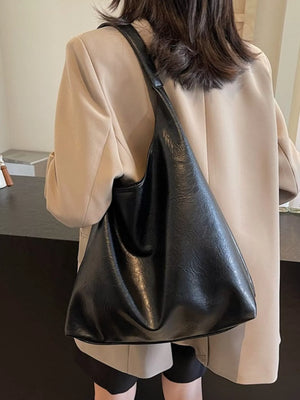 Black PU leather tote bag with a slouchy, sculptural shape.
