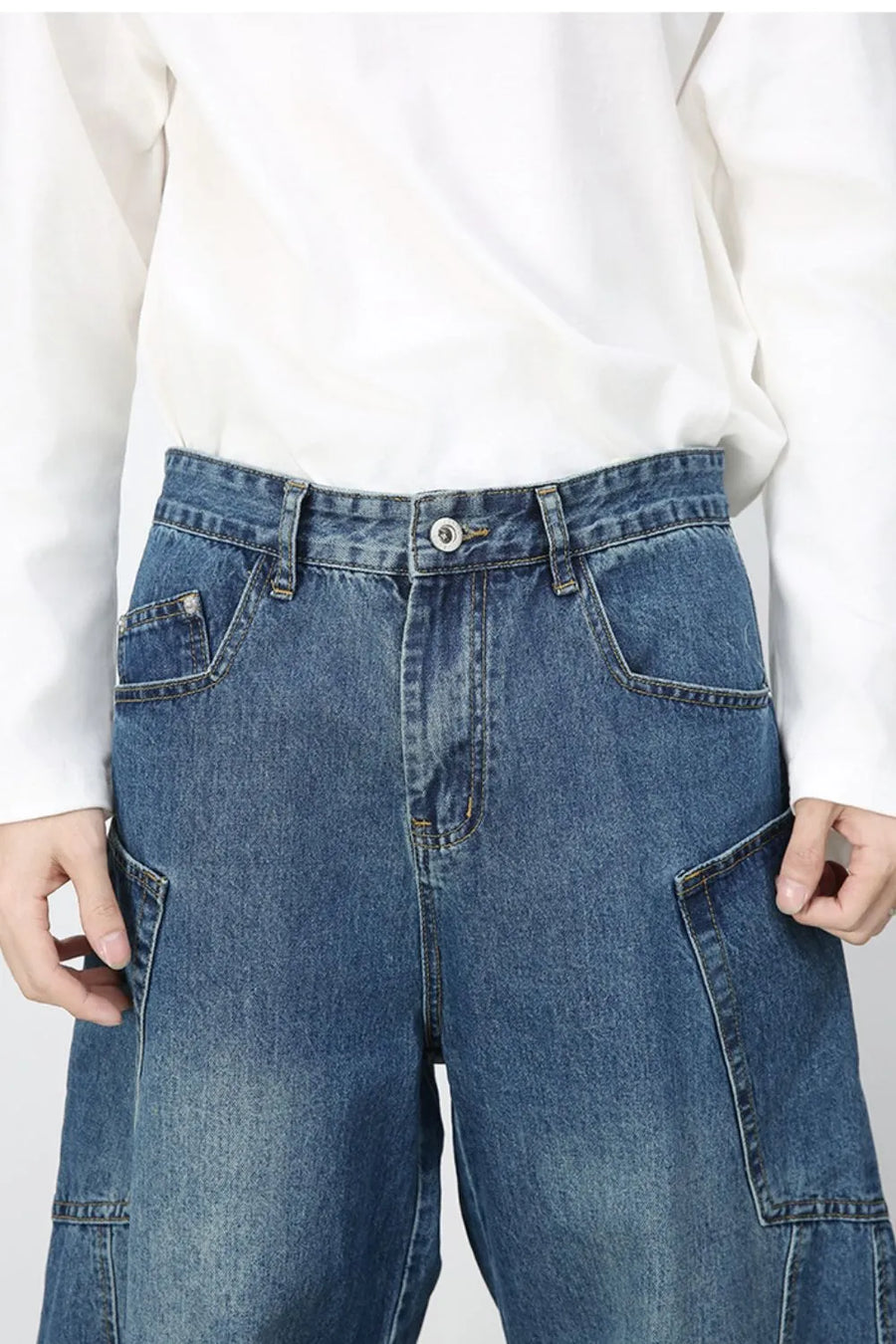 Medium wash denim balloon trousers with cargo pockets and a relaxed fit.