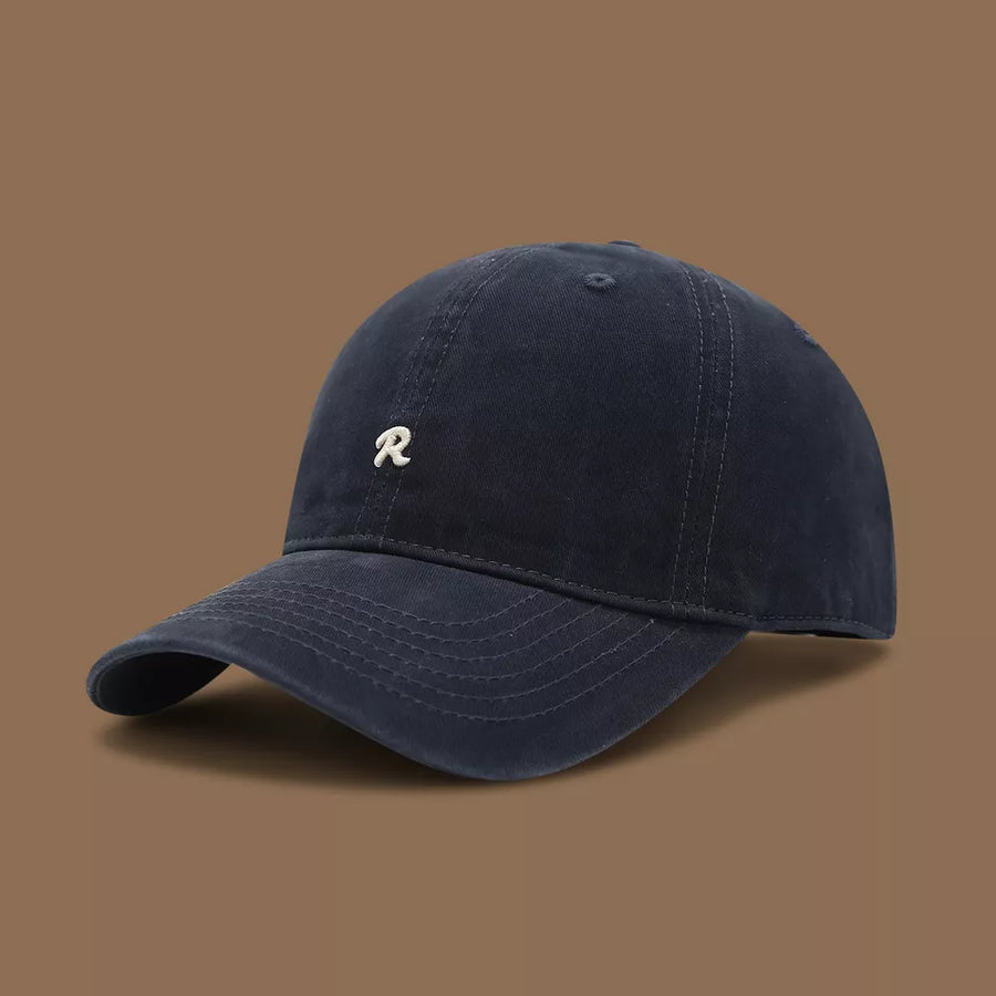 Navy blue cotton baseball cap with embroidered white R logo and curved brim.