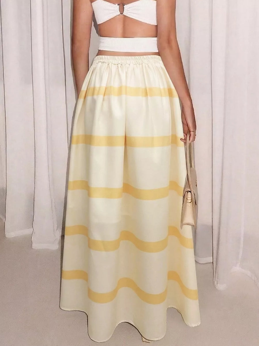 Flowy yellow and white striped maxi skirt with pockets, elastic waist, and a casual A-line cut.