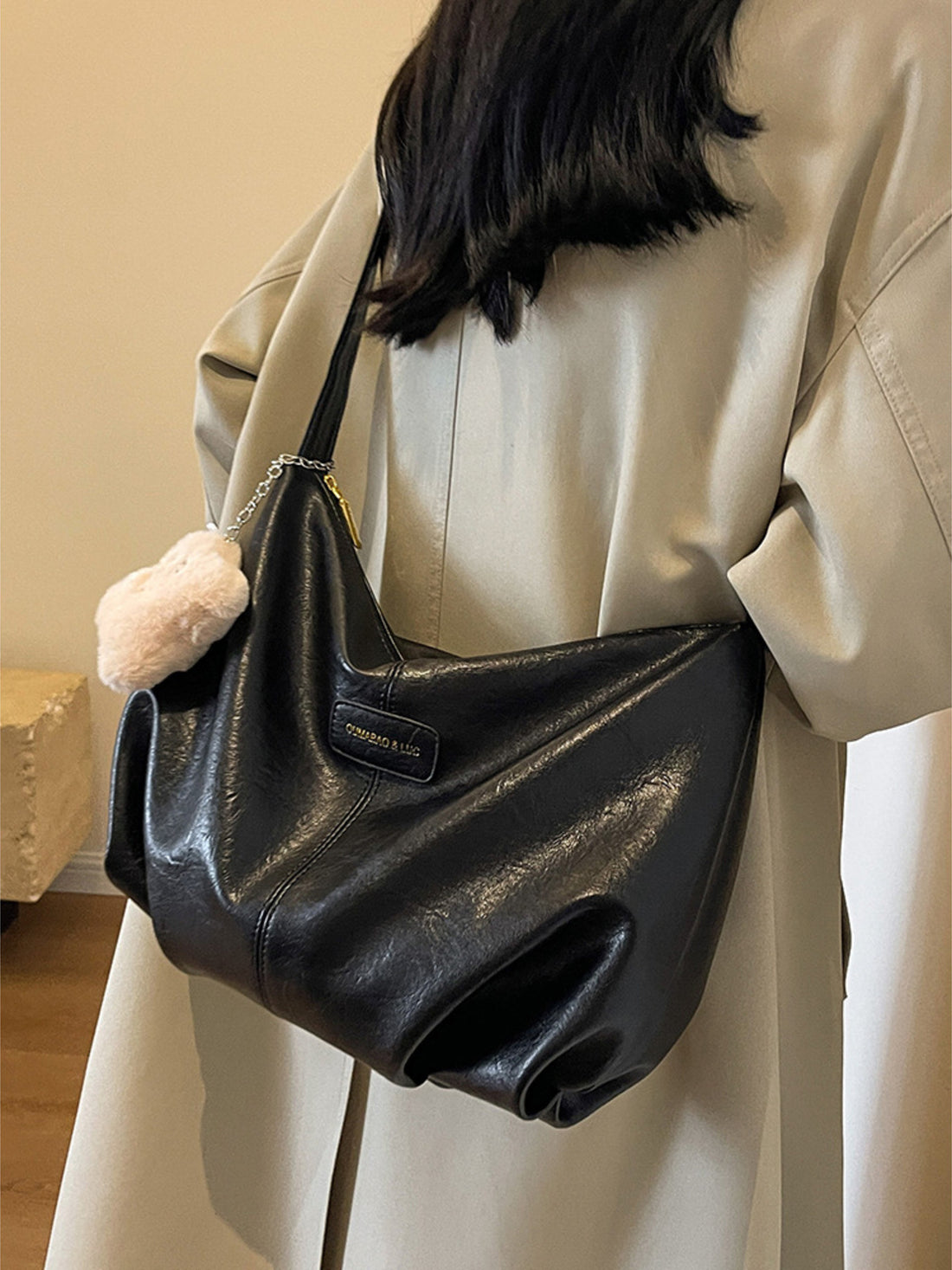 Black pu leather crossbody bag with chain detail and fluffy charm