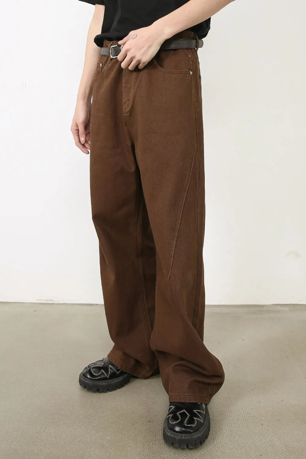 Brown wide-leg denim jeans with angled seams and a casual fit.