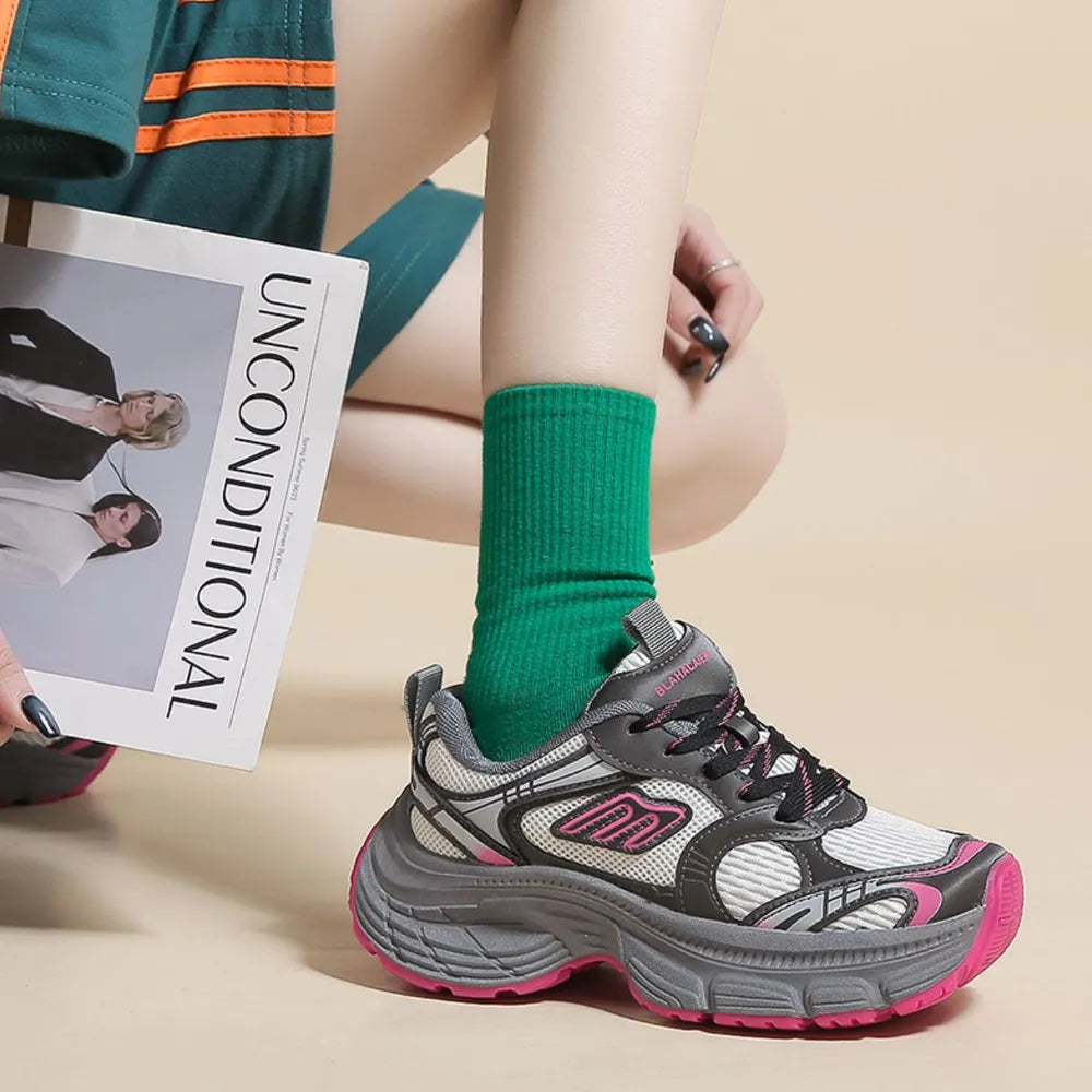 Chunky retro runner sneakers in white with pink and gray accents.