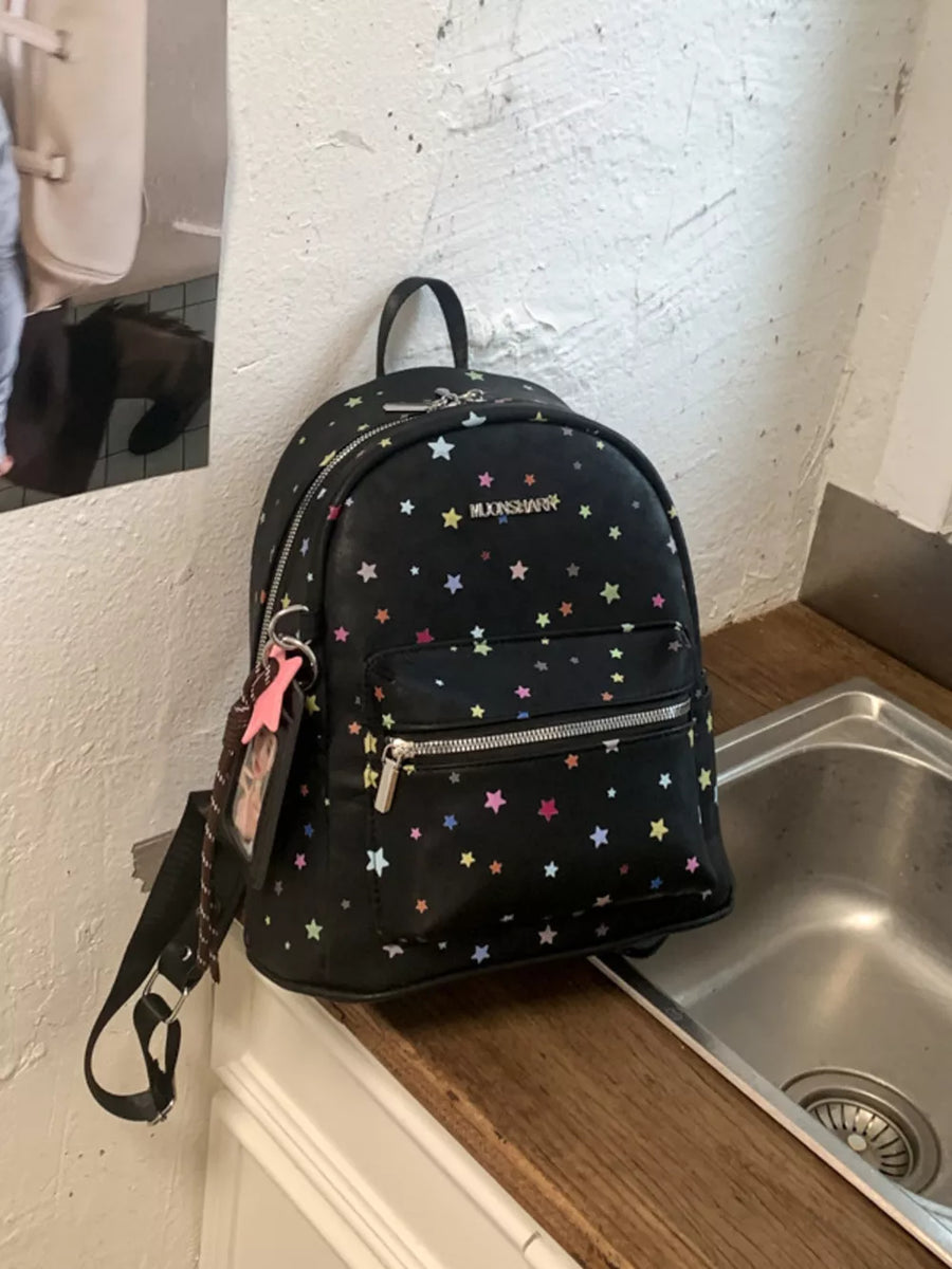Black mini backpack with colorful star print and playful details.